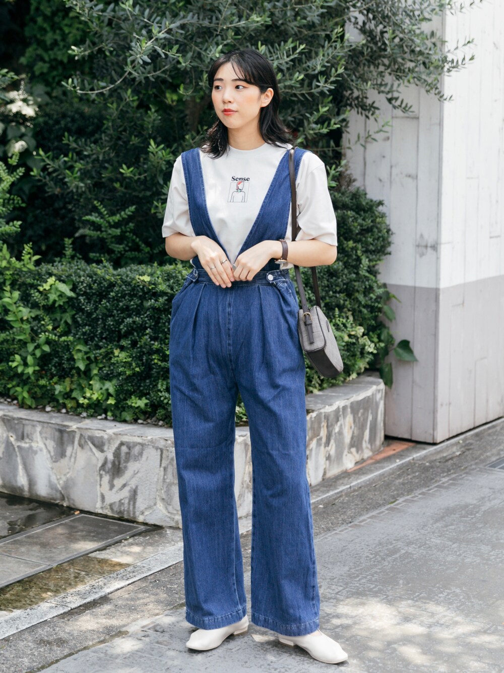 ブルー系のサロペット/オーバーオール、ベージュ系のTシャツ/カットソー、その他のショルダーバッグを着用したレディースの秋コーディネートの1枚目の写真