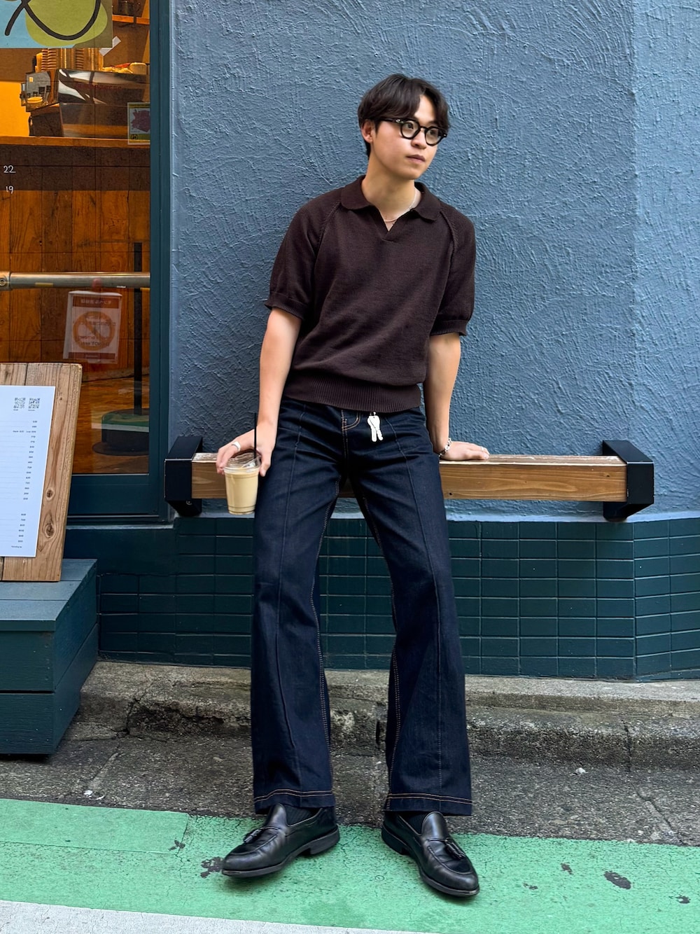 ブラウン系のポロシャツ、ブラック系のデニムパンツ、シルバー系のネックレスを着用したメンズの春コーディネートの1枚目の写真