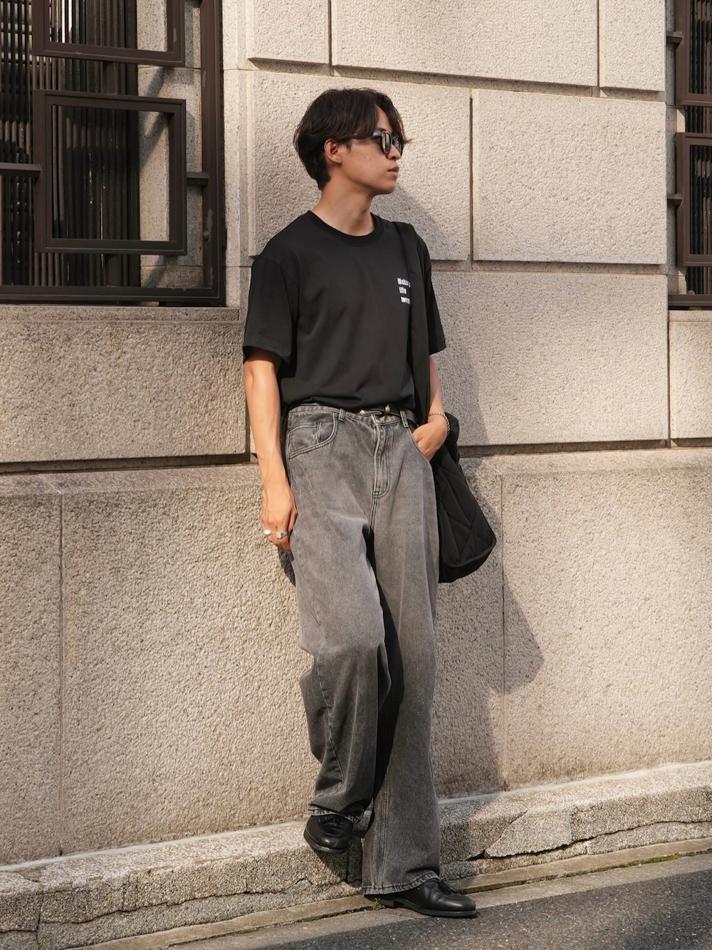 ブラック系のデニムパンツ、ブラック系のローファー、ブラック系のショルダーバッグを着用したメンズの夏コーディネートの1枚目の写真