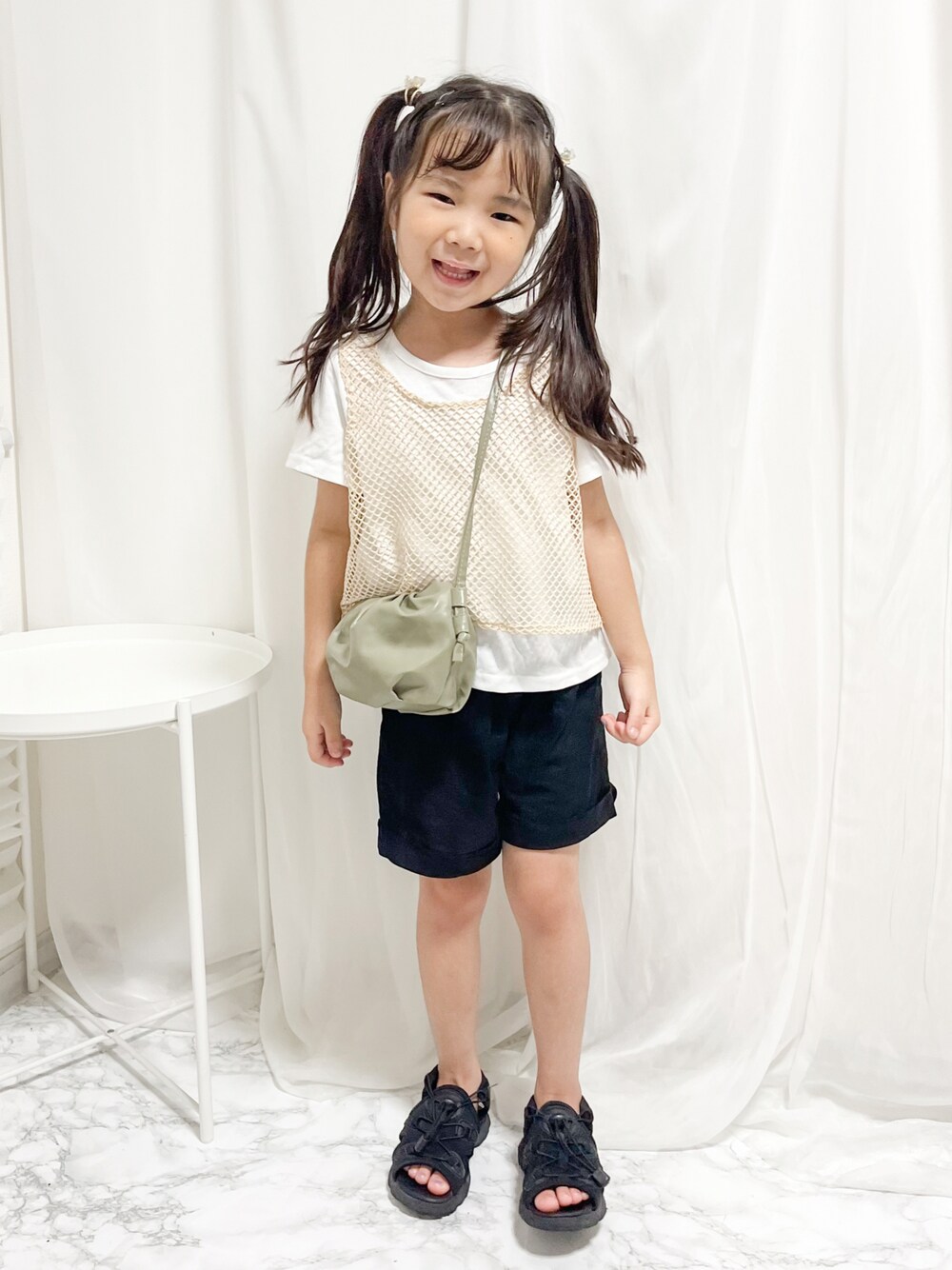 ブラック系のパンツ、ブラック系のサンダル、ホワイト系のTシャツ/カットソーを着用したキッズの夏コーディネートの1枚目の写真