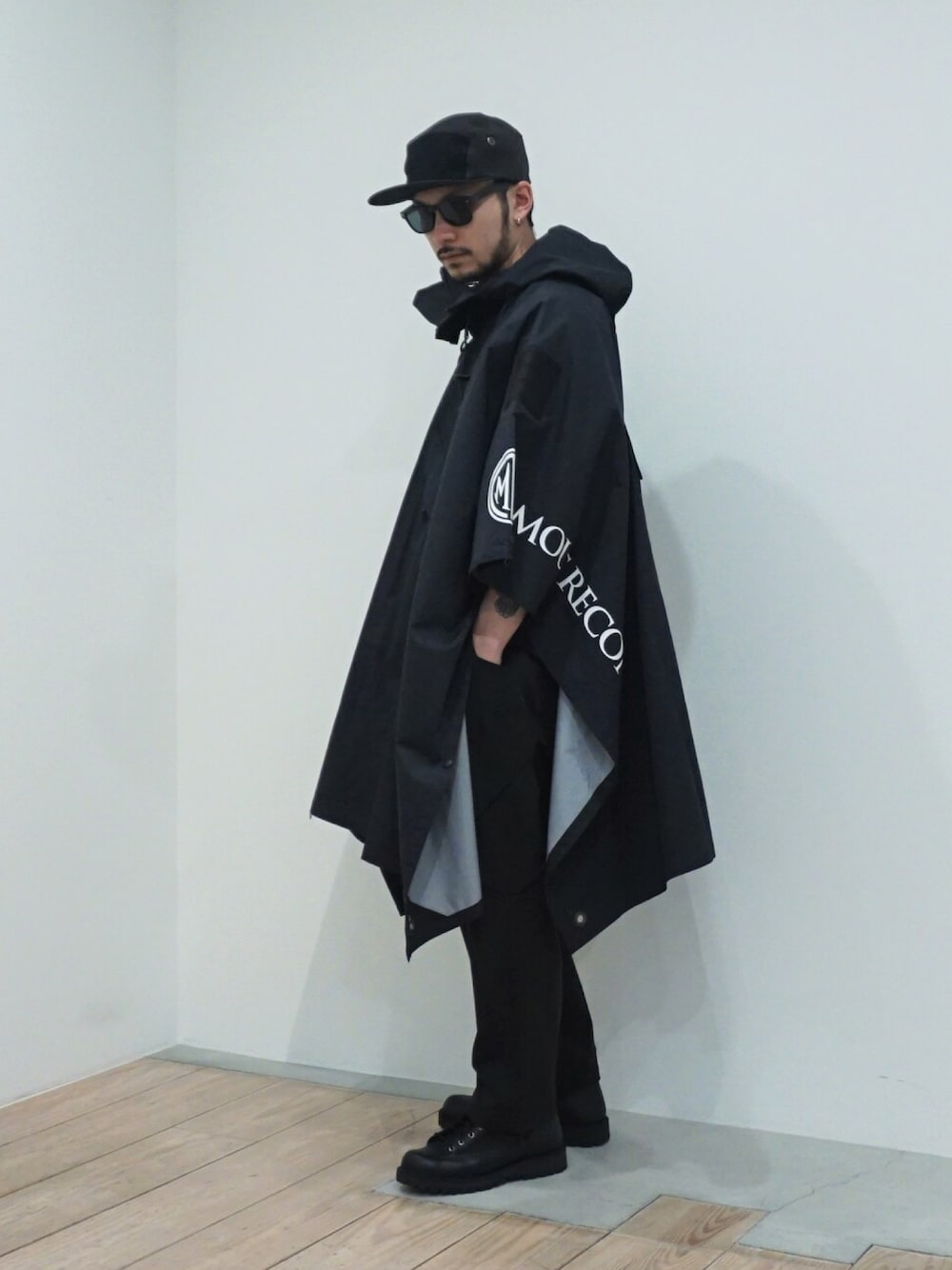 「ブーツ、キャップ、ブラックコーデ、サングラス、Danner、雨の日コーデ、ストリートモード、レインポンチョ、MOUT RECON TAILOR」｜「MOUT RECON TAILORのアイテム（ポンチョ、ブラック系）」を使った、ARKnets STAFFさん（メンズ・178cm）の春コーディネートの1枚目の写真