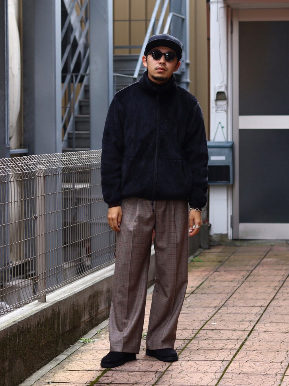 ブラック系のブルゾン、ブラウン系のスラックスを着用したメンズの秋コーディネートの1枚目の写真