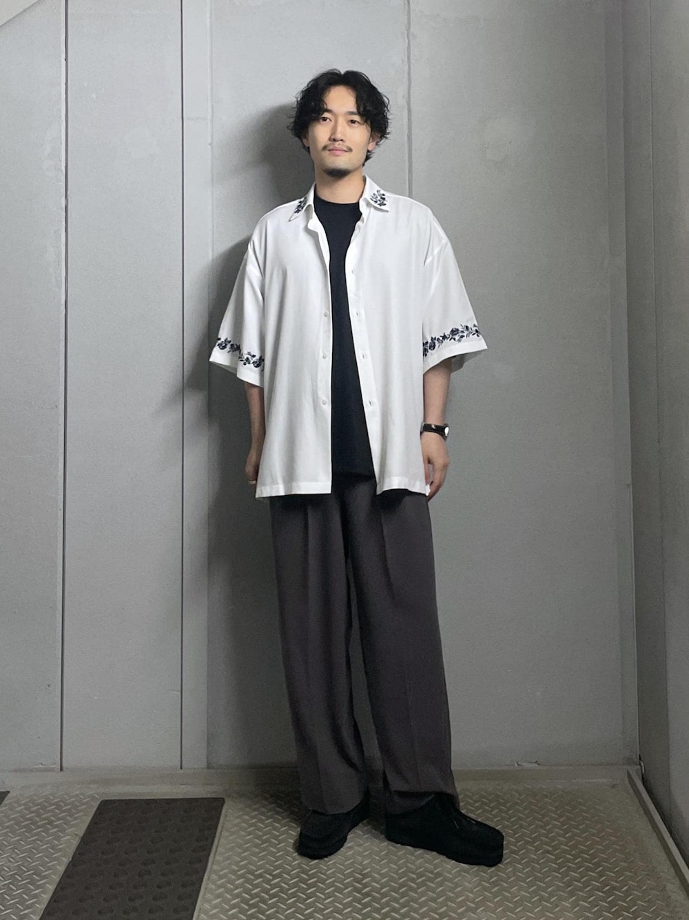 ブラック系のTシャツ/カットソー、ホワイト系のシャツ/ブラウス、グレー系のスラックスを着用したメンズの夏コーディネートの1枚目の写真