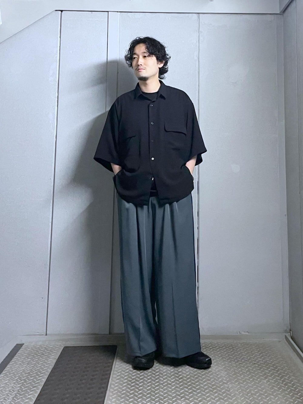 ブラック系のシャツ/ブラウス、グレー系のスラックスを着用したメンズの夏コーディネートの1枚目の写真