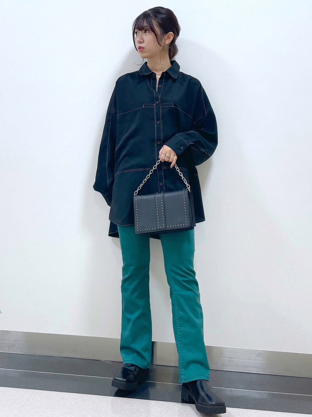 ブラック系のシャツ/ブラウス、ブラック系のショルダーバッグ、グリーン系のデニムパンツを着用したレディースの秋コーディネートの1枚目の写真