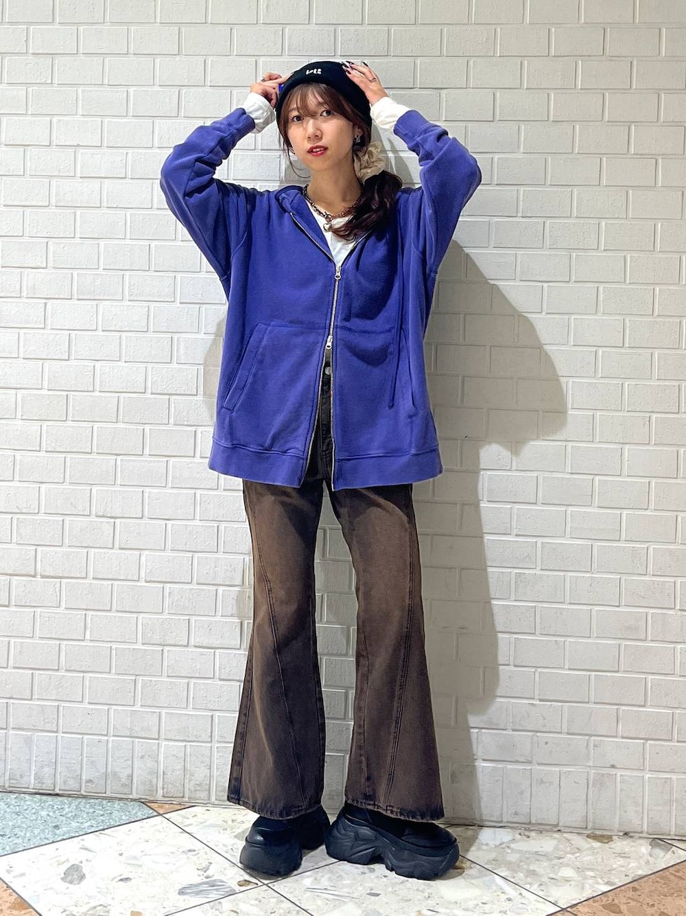 ブラック系のブーツ、ブラウン系のデニムパンツ、ブルー系のパーカーを着用したレディースの秋コーディネートの1枚目の写真