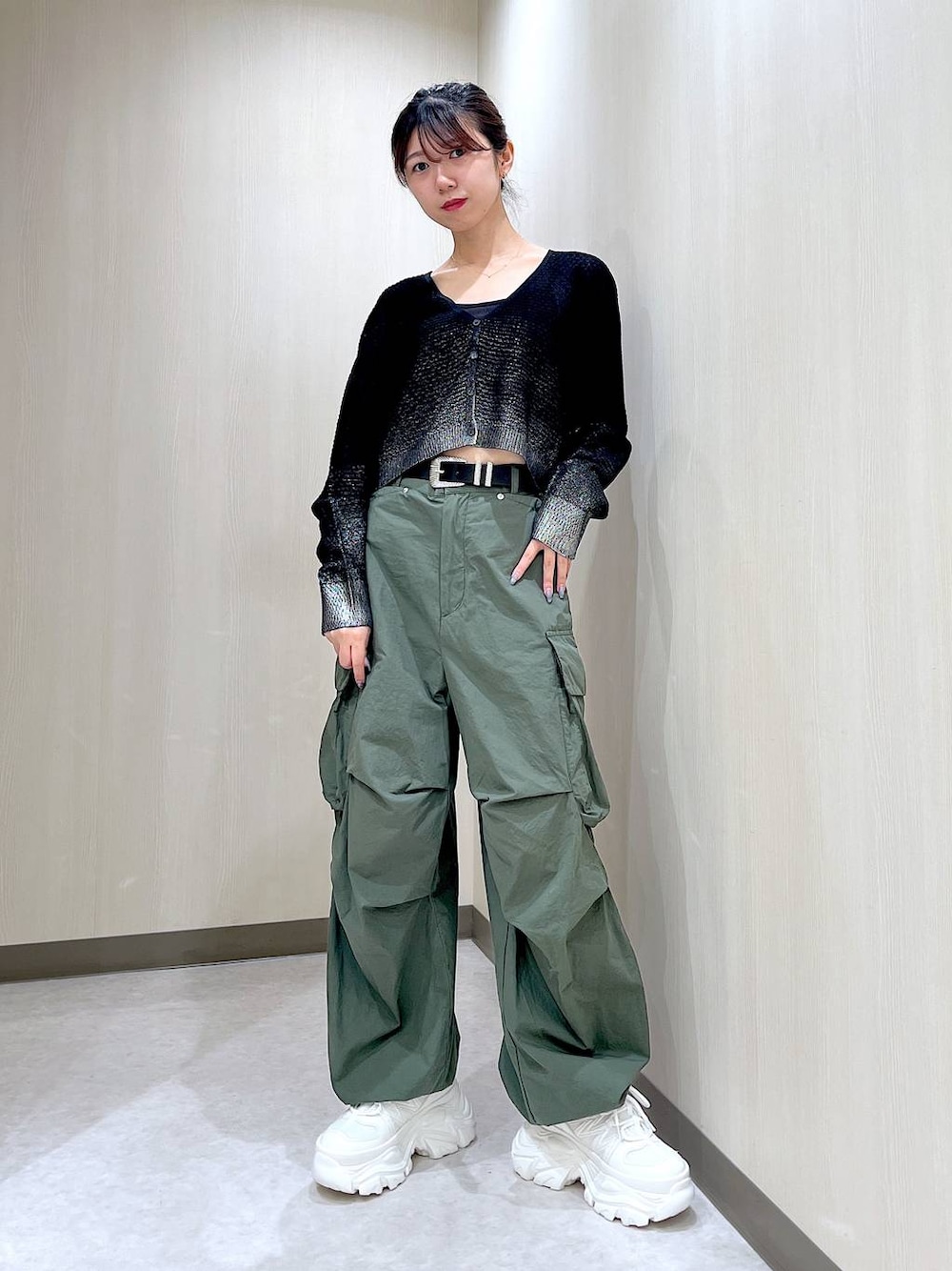 グリーン系のカーゴパンツ、ホワイト系のスニーカー、ブラック系のカーディガン/ボレロを着用したレディースの夏コーディネートの1枚目の写真