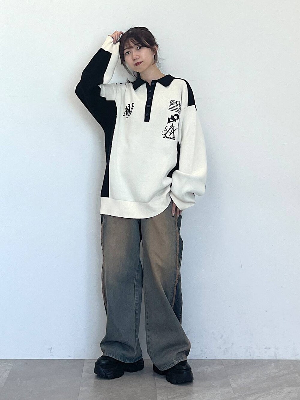 ブルー系のデニムパンツ、ブラック系のブーツ、ブラック系のニット/セーターを着用したレディースの秋コーディネートの1枚目の写真