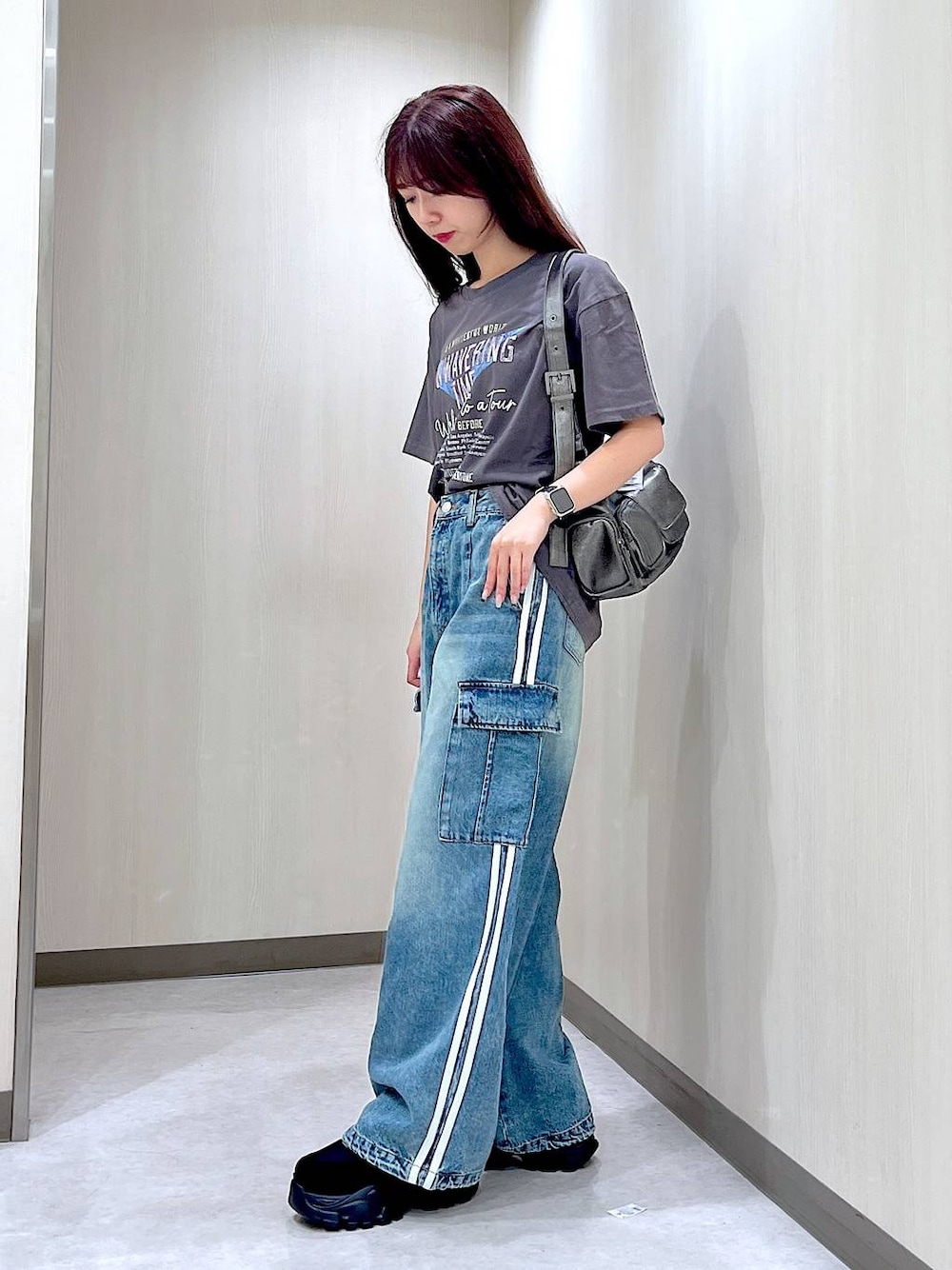 ブルー系のデニムパンツ、ブラック系のスニーカー、グレー系のTシャツ/カットソーを着用したレディースの秋コーディネートの1枚目の写真