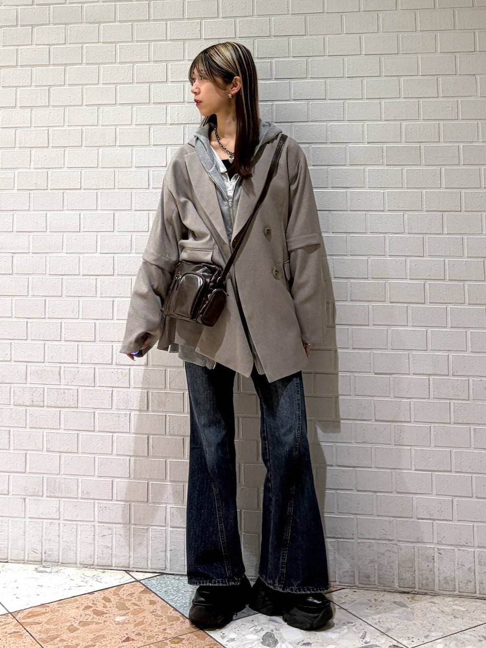 ブラック系のブーツ、ブルー系のデニムパンツ、グレー系のパーカーを着用したレディースの春コーディネートの1枚目の写真