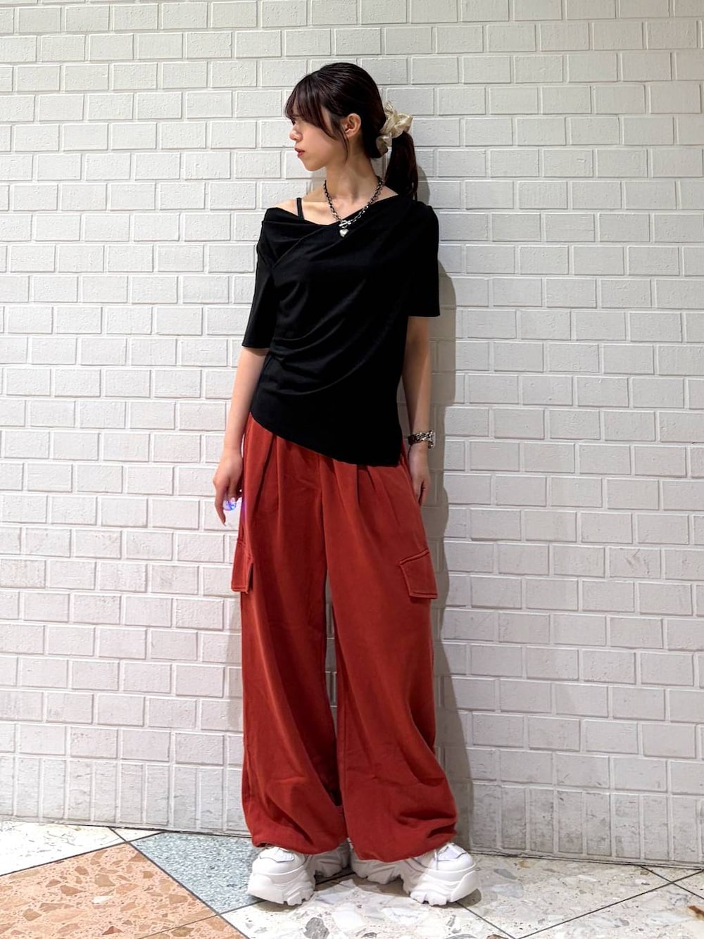 ホワイト系のスニーカー、レッド系のその他パンツ、ブラック系のTシャツ/カットソーを着用したレディースの春コーディネートの1枚目の写真