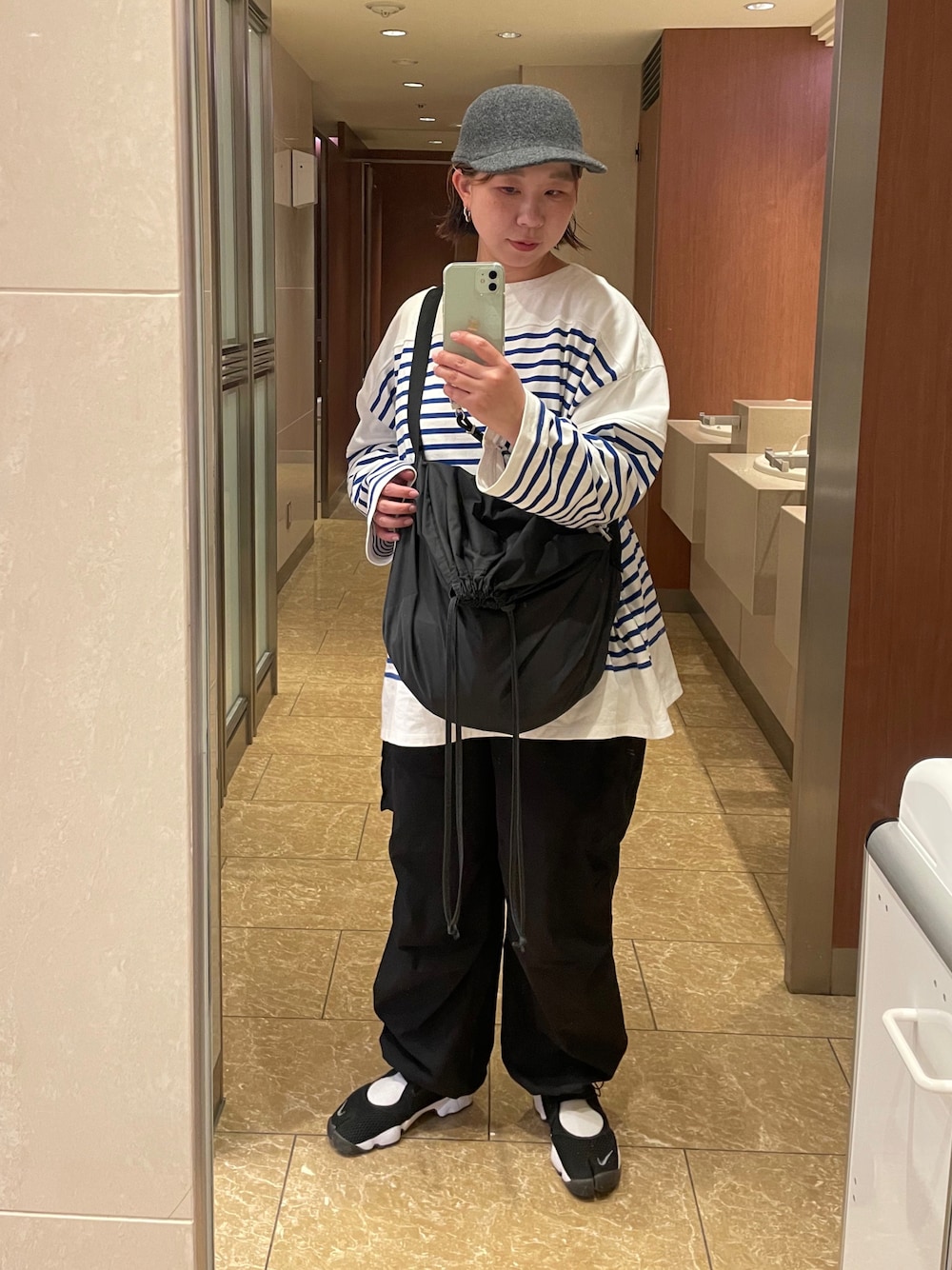 ブルー系のTシャツ/カットソー、ブラック系のスニーカー、ブラック系のショルダーバッグを着用したレディースの秋コーディネートの1枚目の写真