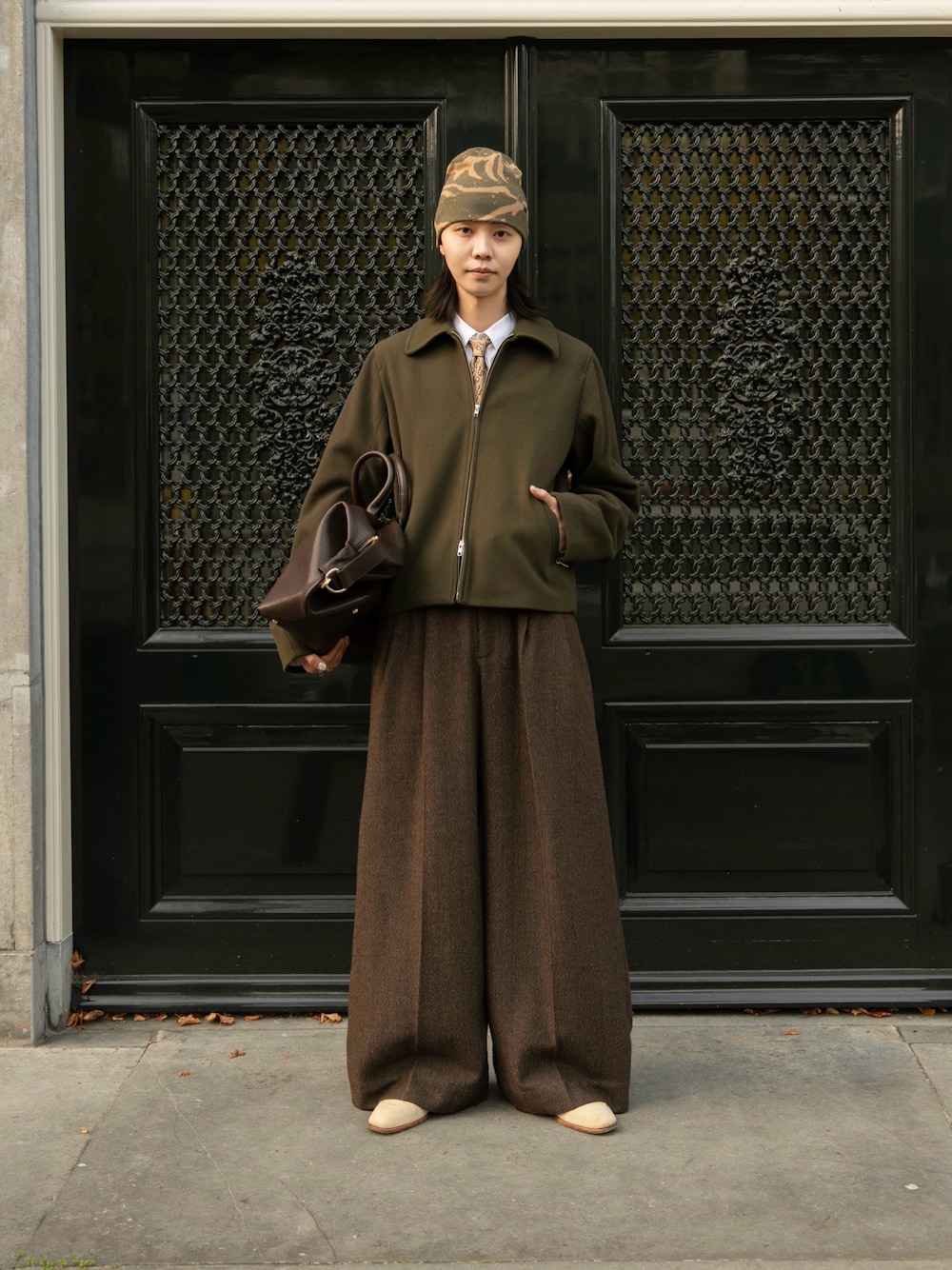 ブラウン系のスラックス、グリーン系のジャケット/アウター、ブラウン系のボストンバッグを着用したメンズの秋コーディネートの1枚目の写真