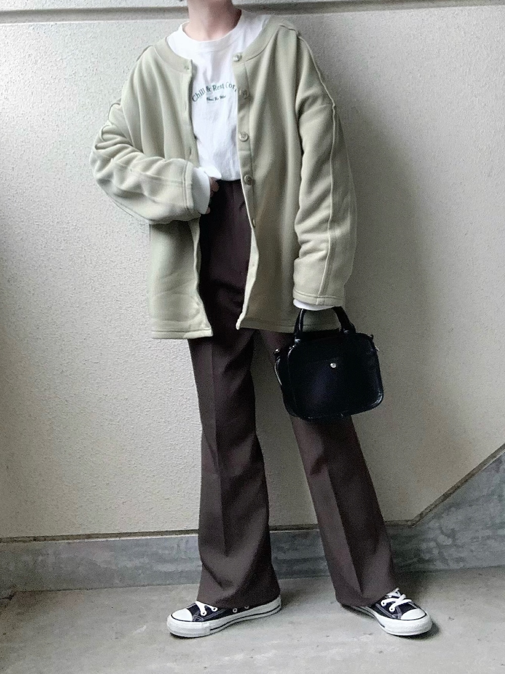 グリーン系のカーディガン/ボレロ、ホワイト系のTシャツ/カットソー、グレー系のスラックスを着用したレディースの冬コーディネートの1枚目の写真