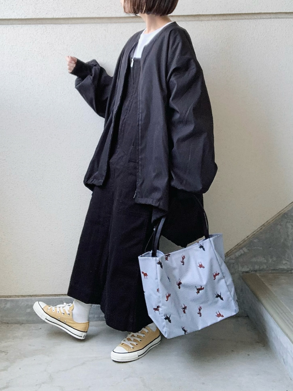 ブラック系のワンピース、ブラック系のブルゾン、ブルー系のトートバッグを着用したレディースの春コーディネートの1枚目の写真