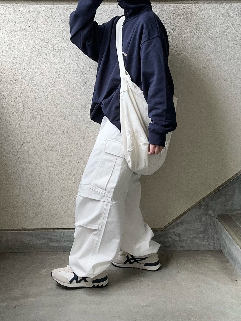 ホワイト系のカーゴパンツ、ブルー系のスウェット、ホワイト系のショルダーバッグを着用したレディースの冬コーディネートの1枚目の写真