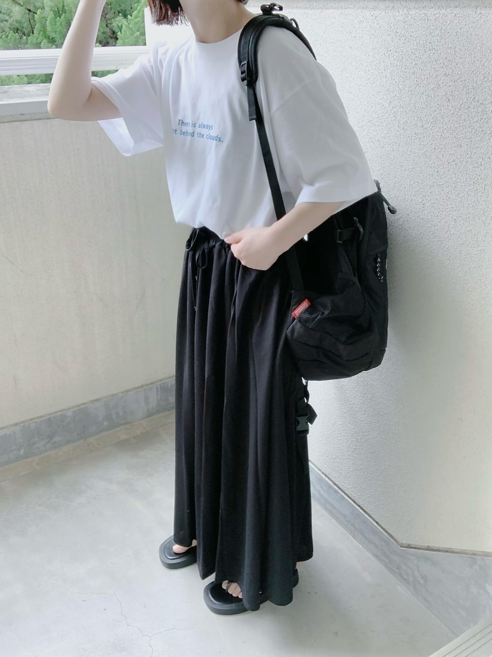 ブルー系のTシャツ/カットソー、ブラック系のスカート、ブラック系のサンダルを着用したレディースの春コーディネートの1枚目の写真