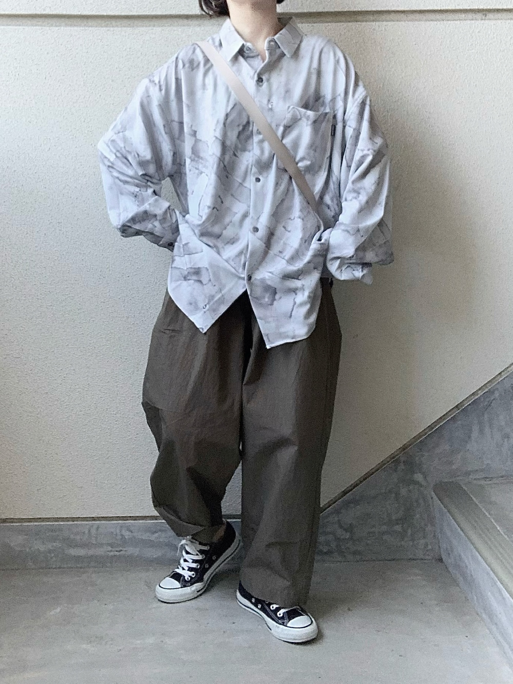 グレー系のシャツ/ブラウス、ブラウン系のその他パンツ、ホワイト系のショルダーバッグを着用したレディースの春コーディネートの1枚目の写真