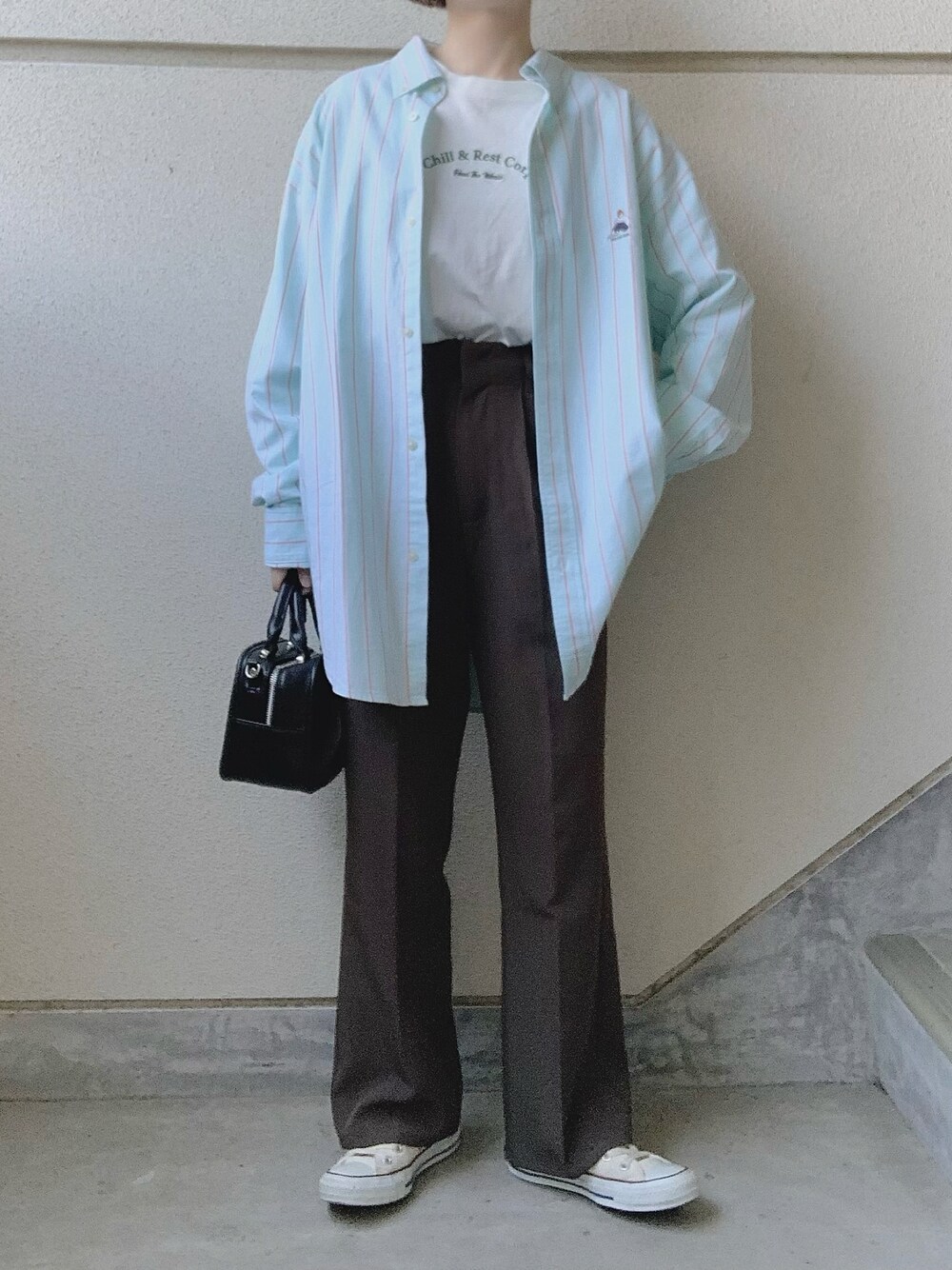 グリーン系のシャツ/ブラウス、グレー系のスラックス、ホワイト系のスニーカーを着用したレディースの冬コーディネートの1枚目の写真