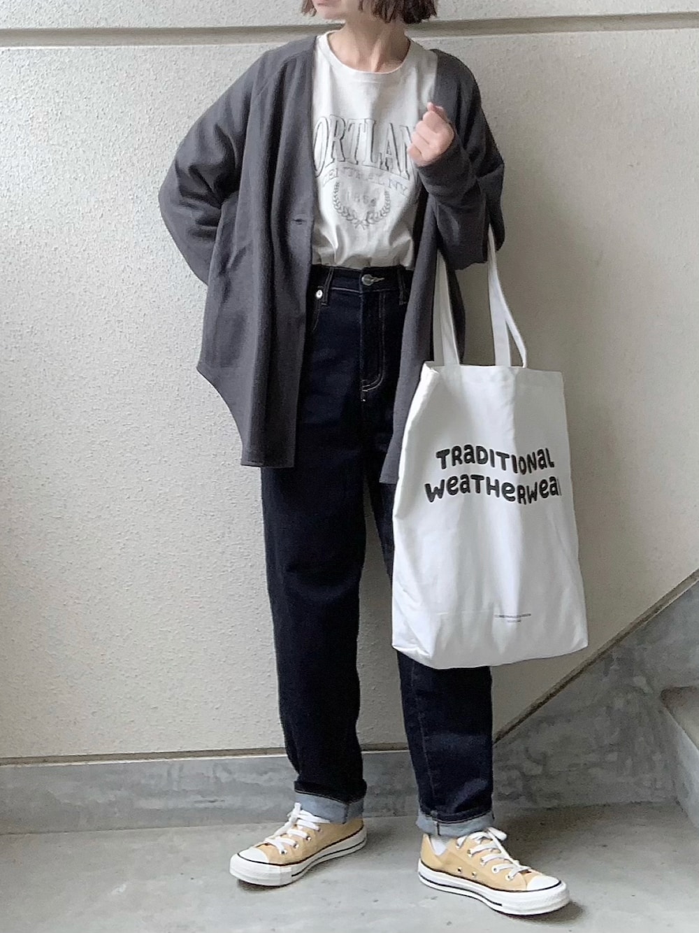 グレー系のカーディガン/ボレロ、ブルー系のデニムパンツ、ホワイト系のトートバッグを着用したレディースの秋コーディネートの1枚目の写真