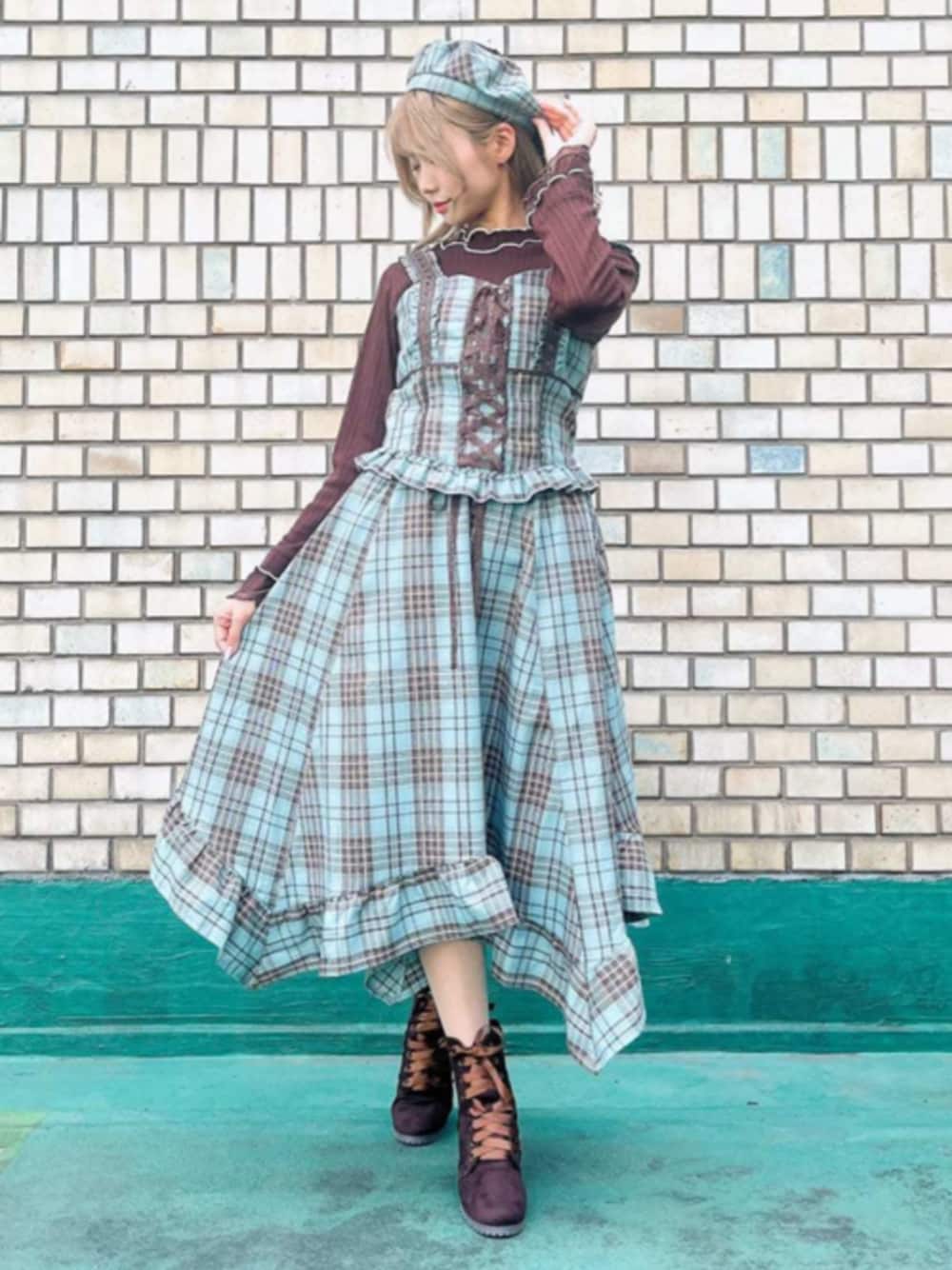 ブラウン系のTシャツ/カットソー、グリーン系のベスト、グリーン系のスカートを着用したレディースの秋コーディネートの1枚目の写真