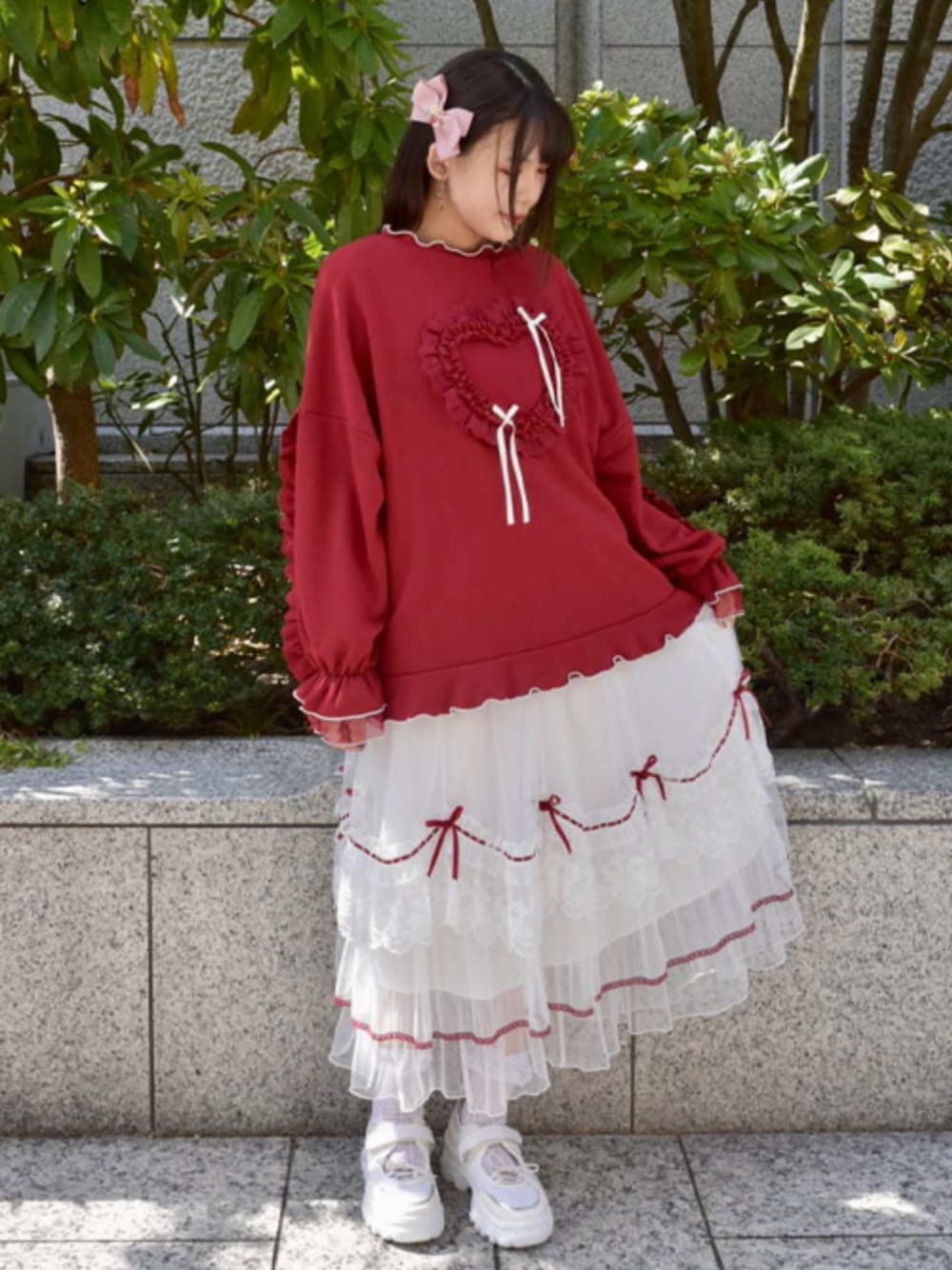 レッド系のTシャツ/カットソー、ホワイト系のスカート、ホワイト系のスニーカーを着用したレディースの秋コーディネートの1枚目の写真