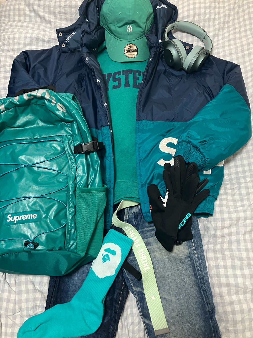 ブルー系のダウンジャケット/コート、グリーン系のスウェット、グリーン系のバックパック/リュックを着用したメンズの春コーディネートの1枚目の写真