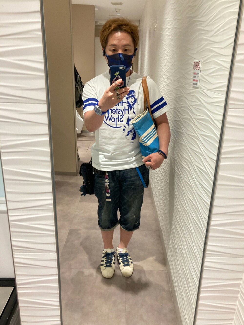 ホワイト系のTシャツ/カットソー、ブルー系のトートバッグ、ブルー系のデニムパンツを着用したメンズの夏コーディネートの1枚目の写真