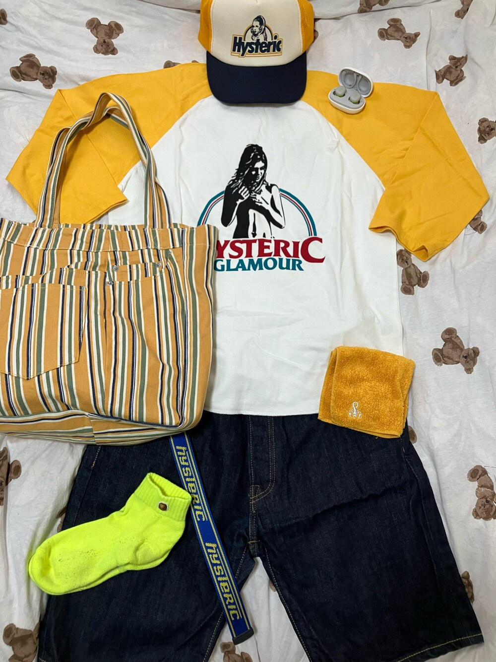 イエロー系のTシャツ/カットソー、イエロー系のトートバッグ、ブルー系のデニムパンツを着用したメンズの夏コーディネートの1枚目の写真