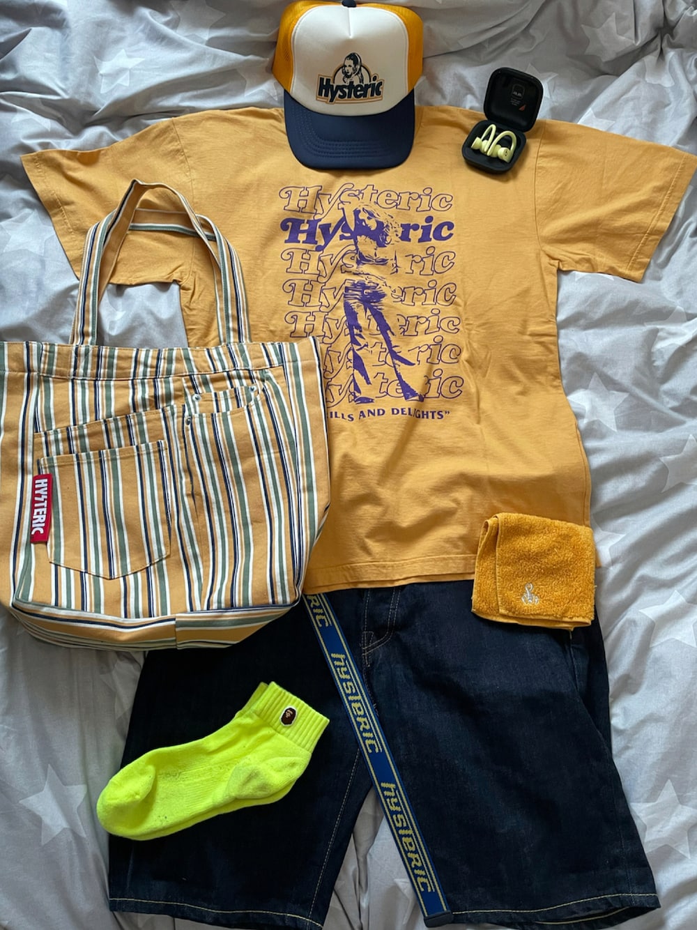 イエロー系のTシャツ/カットソー、イエロー系のトートバッグ、ブルー系のデニムパンツを着用したメンズの夏コーディネートの1枚目の写真