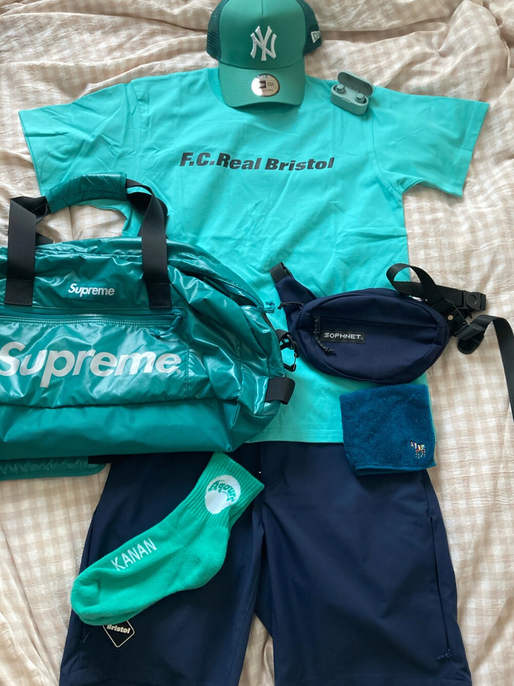 ブルー系のTシャツ/カットソー、グリーン系のドラムバッグ、ブルー系のボディバッグ/ウエストポーチを着用したメンズの夏コーディネートの1枚目の写真