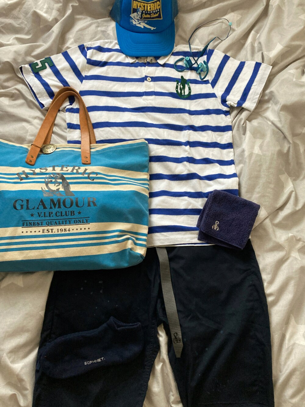 ブルー系のポロシャツ、ブルー系のトートバッグ、ブルー系のその他パンツを着用したメンズの夏コーディネートの1枚目の写真