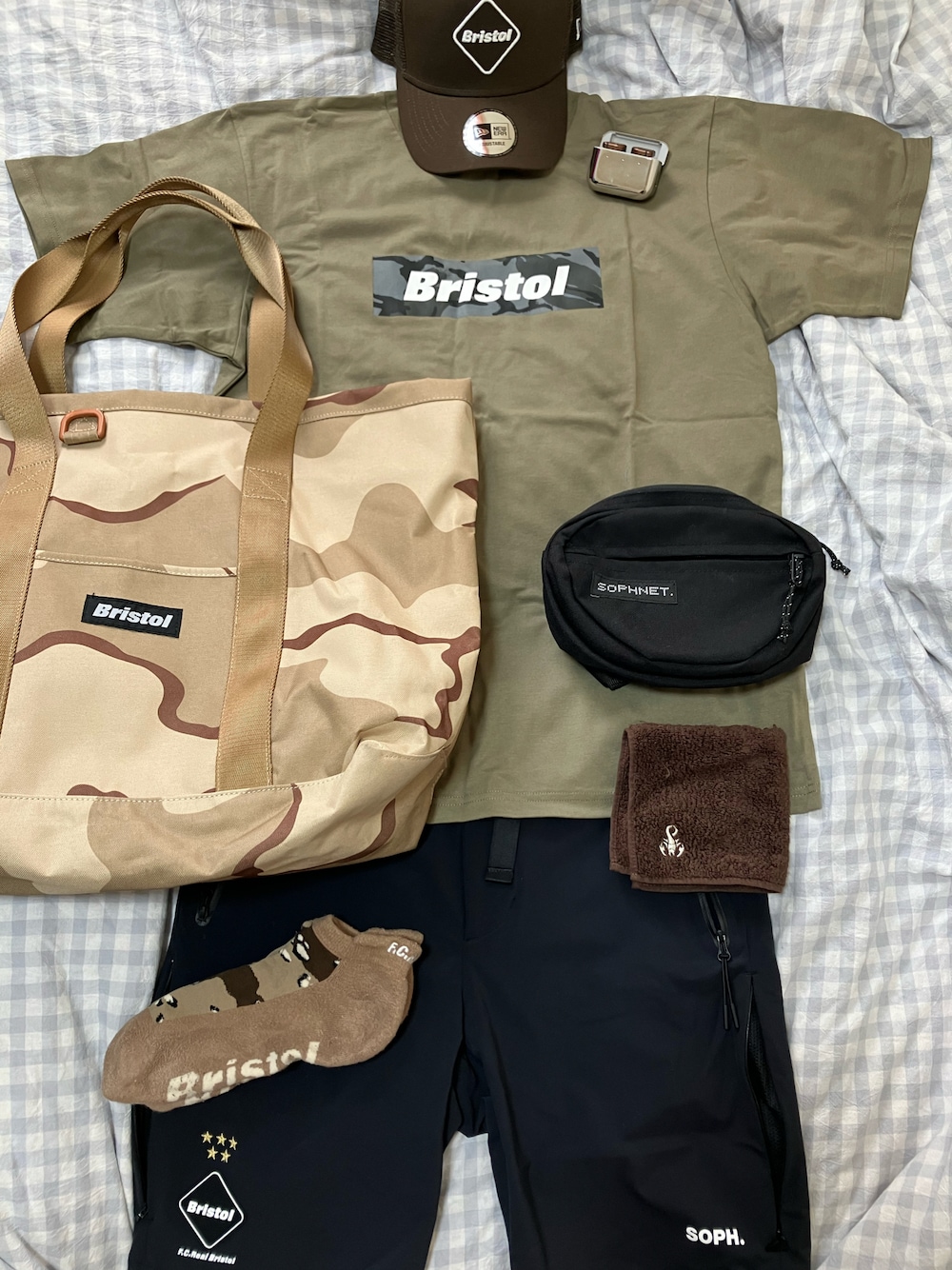 ベージュ系のTシャツ/カットソー、ベージュ系のトートバッグ、ブラック系のボディバッグ/ウエストポーチを着用したメンズの夏コーディネートの1枚目の写真