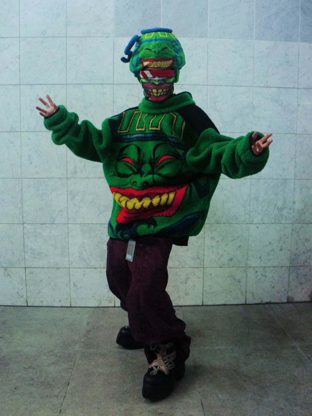 ピンク系のデニムパンツ、ブラック系のブーツ、グリーン系のブルゾンを着用したメンズの秋コーディネートの1枚目の写真