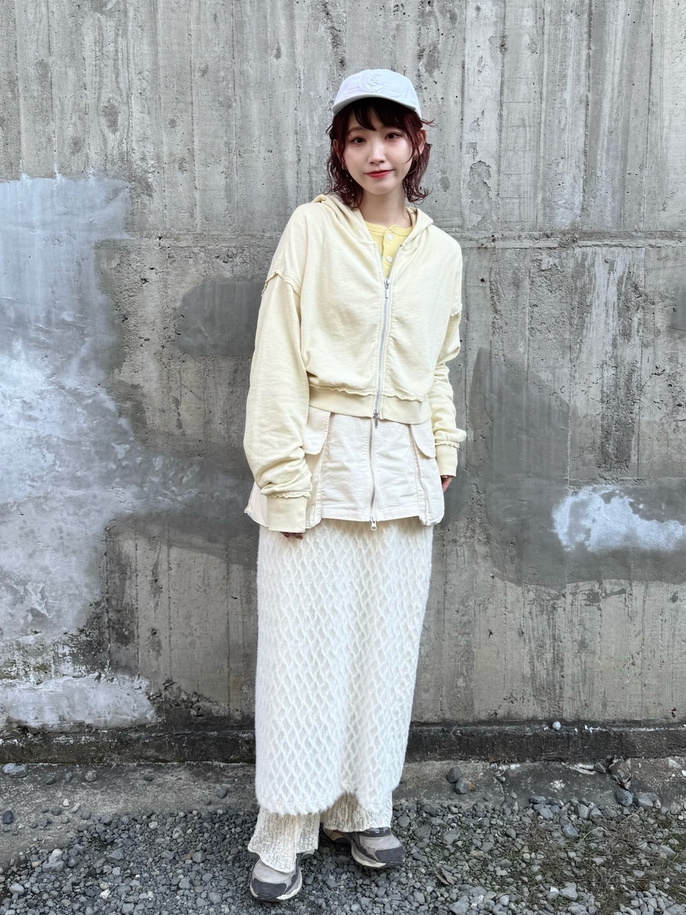 イエロー系のパーカー、ホワイト系のスカート、ホワイト系のその他パンツを着用したレディースの冬コーディネートの1枚目の写真