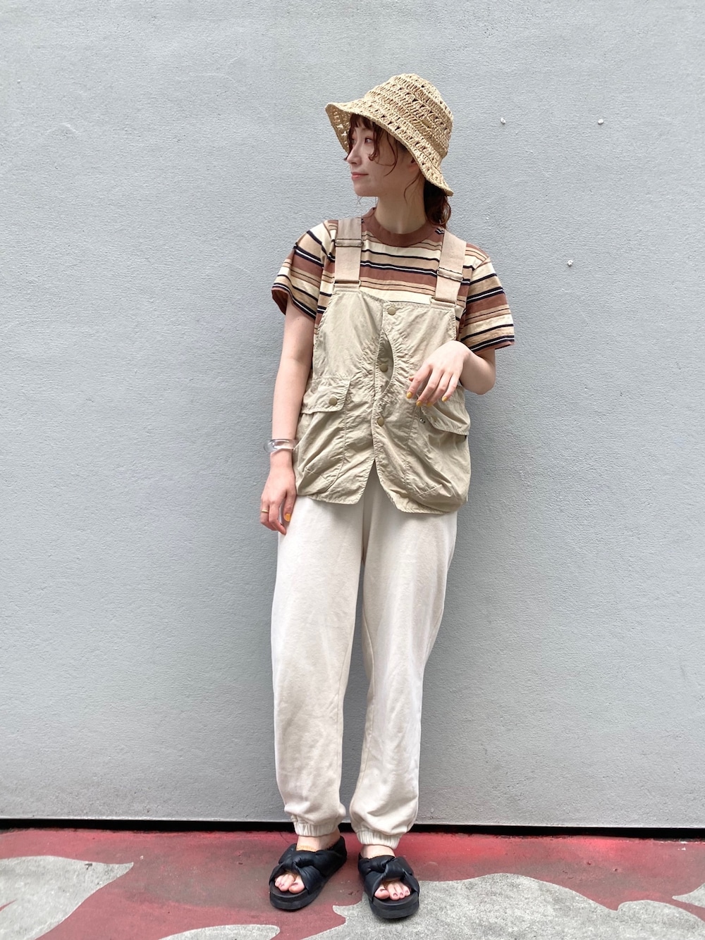 ブラウン系のTシャツ/カットソー、ベージュ系のベスト、ホワイト系のスウェットパンツを着用したレディースの春コーディネートの1枚目の写真