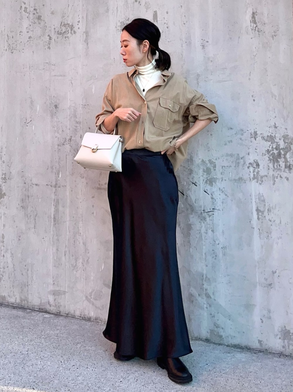 イエロー系のシャツ/ブラウス、ブラック系のスカート、ブラック系のブーツを着用したレディースの春コーディネートの1枚目の写真