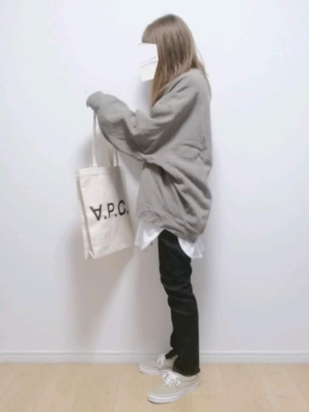 ブラック系のデニムパンツ、ベージュ系のスニーカー、ホワイト系のトートバッグを着用したレディースの秋コーディネートの1枚目の写真