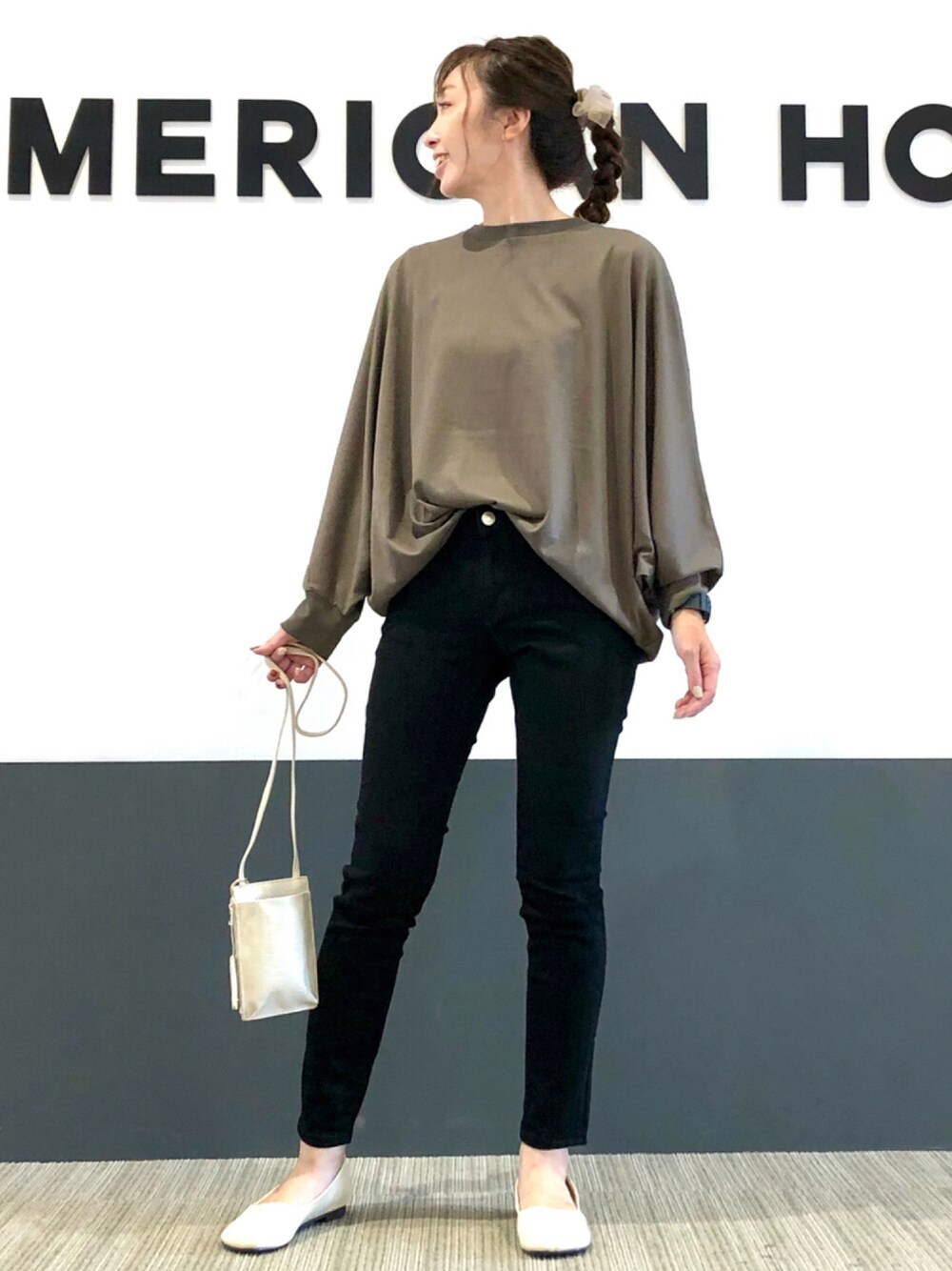 ブラック系のデニムパンツ、ブラウン系のTシャツ/カットソー、ホワイト系のショルダーバッグを着用したレディースの秋コーディネートの1枚目の写真