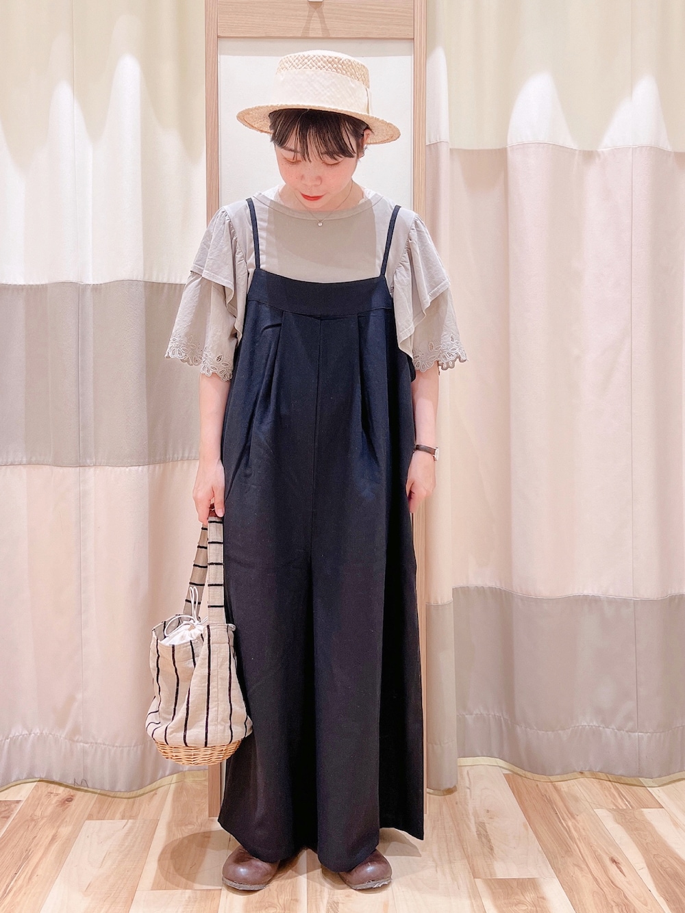 ブラウン系のTシャツ/カットソー、ブラック系のサロペット/オーバーオール、ベージュ系のかごバッグを着用したレディースの夏コーディネートの1枚目の写真
