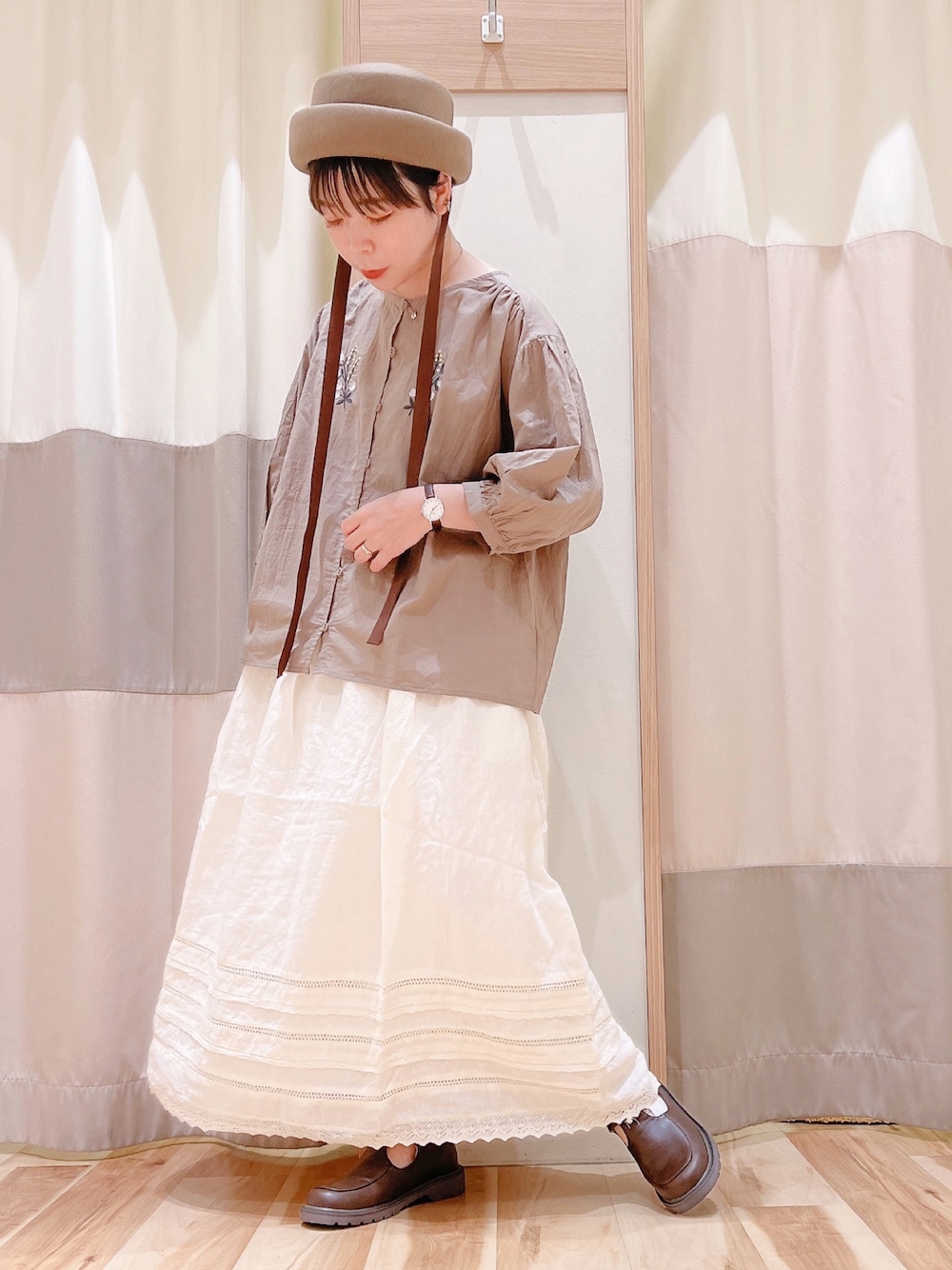 ブラウン系のシャツ/ブラウス、ベージュ系のスカート、ブラック系のハンドバッグを着用したレディースの夏コーディネートの1枚目の写真