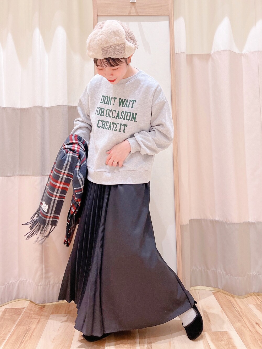 グレー系のTシャツ/カットソー、ブラック系のスカート、グレー系のストール/ショールを着用したレディースの秋コーディネートの1枚目の写真
