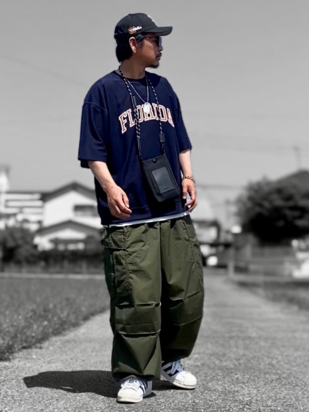 ブルー系のTシャツ/カットソー、グリーン系のカーゴパンツ、ホワイト系のスニーカーを着用したメンズの春コーディネートの1枚目の写真