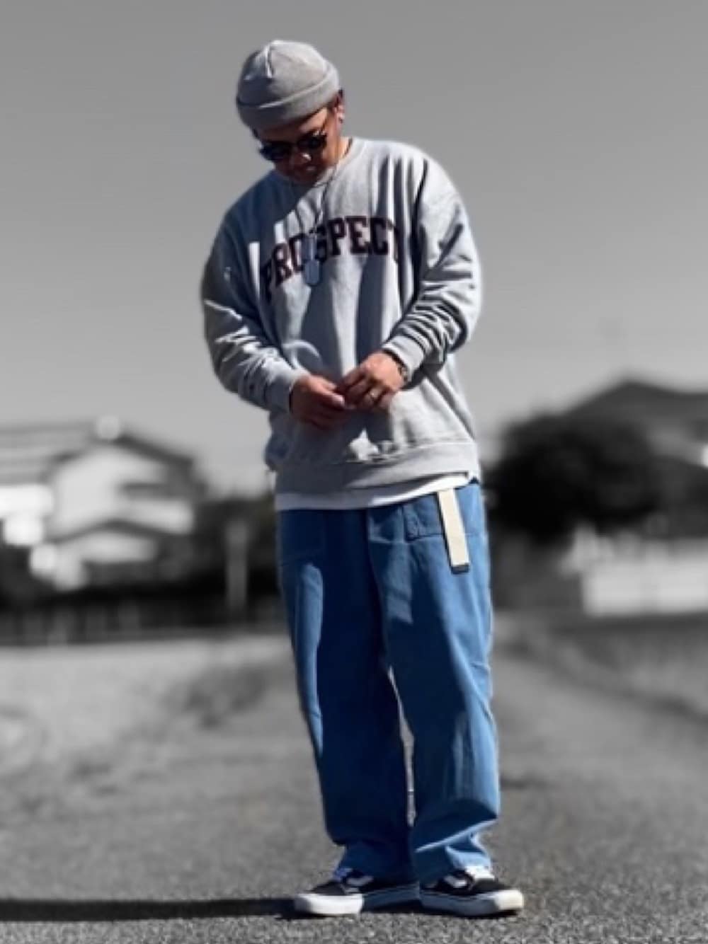 グレー系のスウェット、ブルー系のデニムパンツ、ブラック系のスニーカーを着用したメンズの秋コーディネートの1枚目の写真