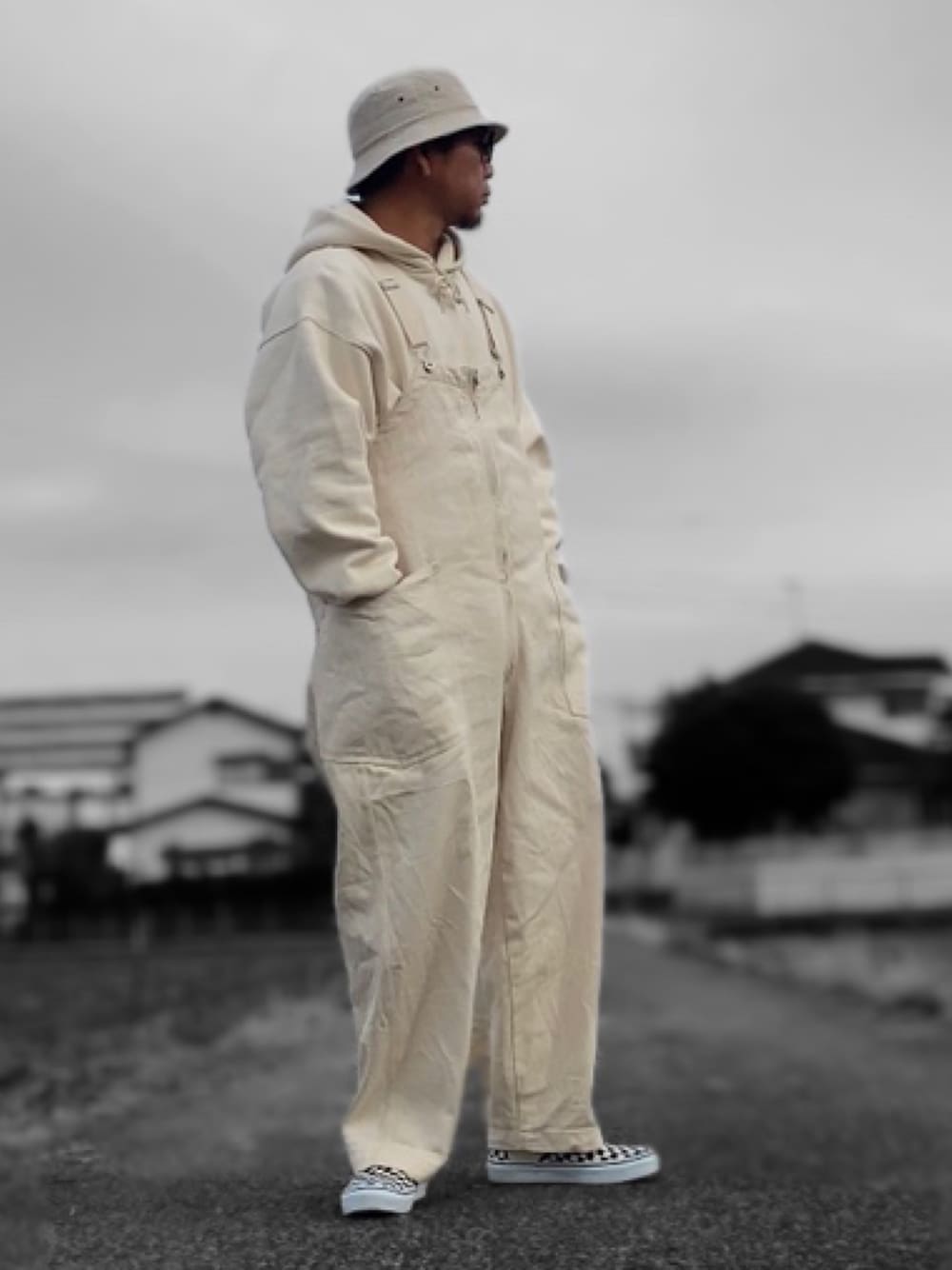 ホワイト系のパーカー、ホワイト系のサロペット/オーバーオール、ホワイト系のスリッポンを着用したメンズの秋コーディネートの1枚目の写真