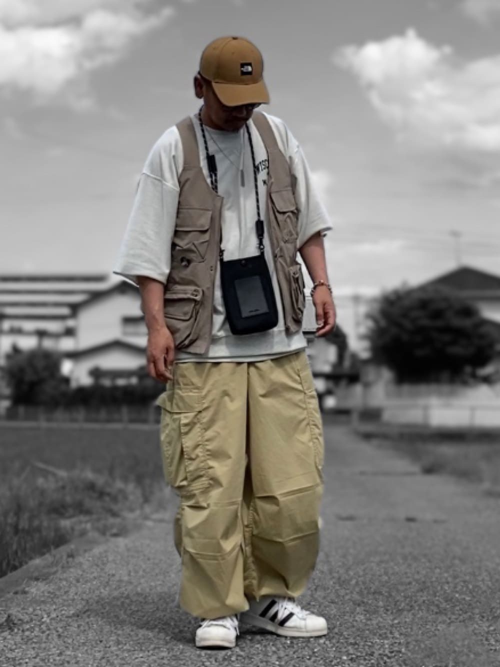 グレー系のTシャツ/カットソー、その他のベスト、ブラック系のショルダーバッグを着用したメンズの春コーディネートの1枚目の写真