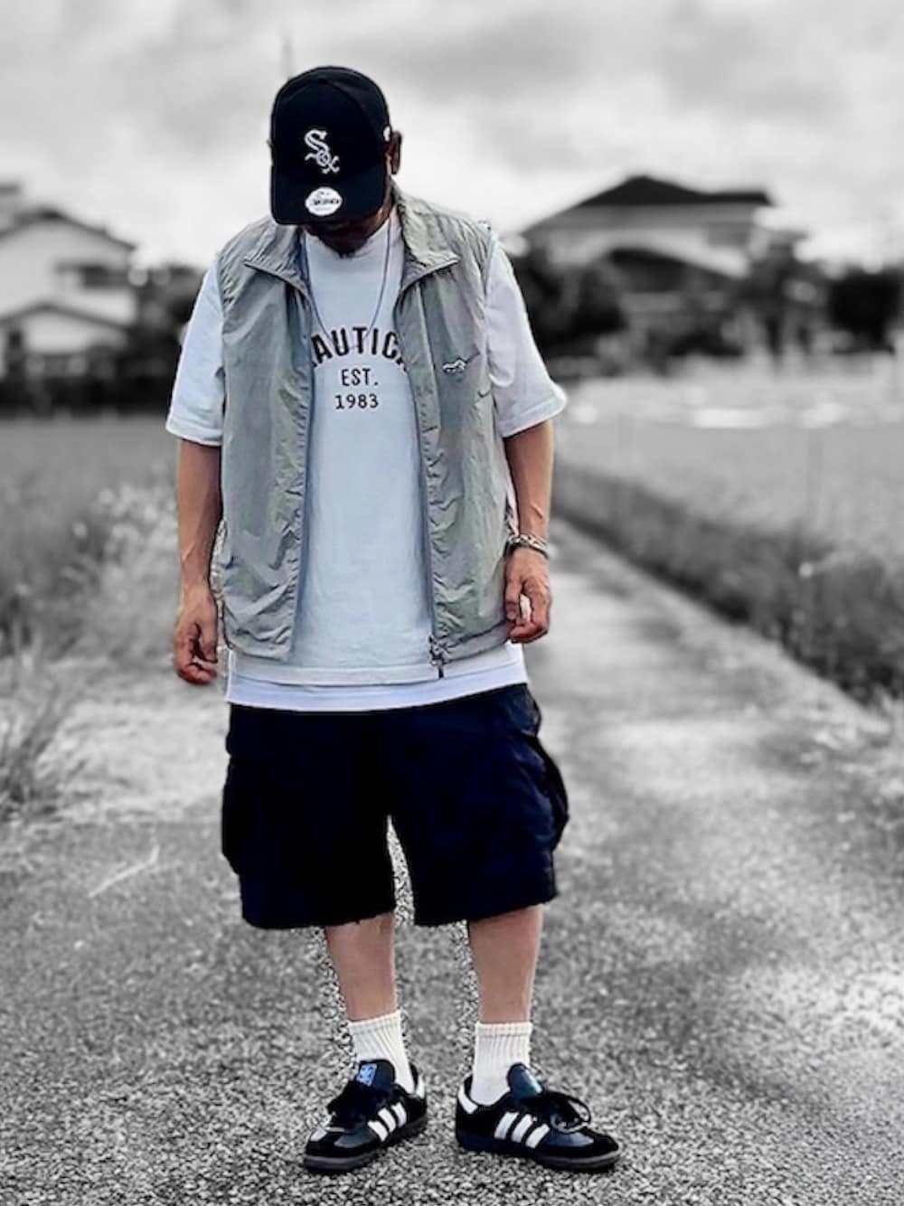 ホワイト系のTシャツ/カットソー、グレー系のベスト、ブラック系のカーゴパンツを着用したメンズの夏コーディネートの1枚目の写真