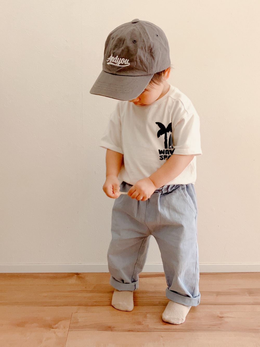 ホワイト系のTシャツ/カットソー、ブルー系のパンツ、グレー系のキャップを着用したキッズの秋コーディネートの1枚目の写真