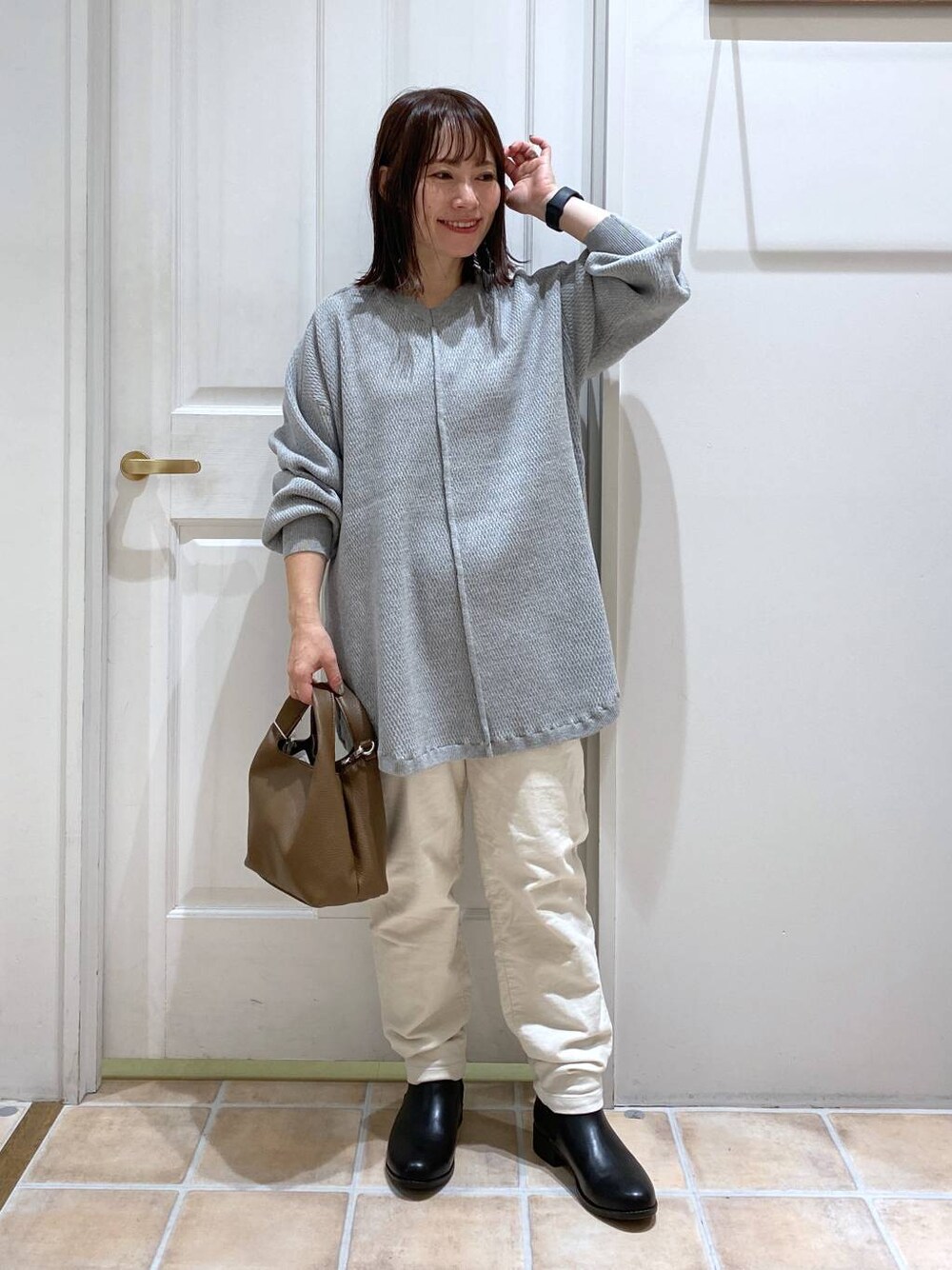 ホワイト系のその他パンツ、ブラック系のブーツ、ブラウン系のショルダーバッグを着用したレディースの秋コーディネートの1枚目の写真