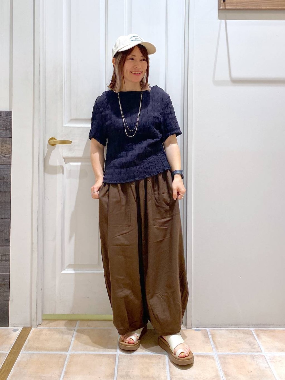 ベージュ系のサンダル、ブラウン系のその他パンツ、ブラック系のシャツ/ブラウスを着用したレディースの夏コーディネートの1枚目の写真